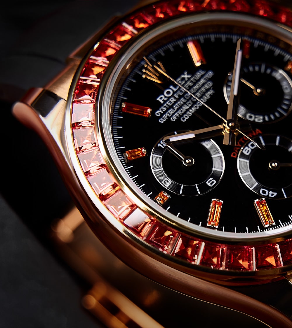 Image of a Rolex Daytona 40mm with a custom chronograph black dial and orange bezel by Cagau.