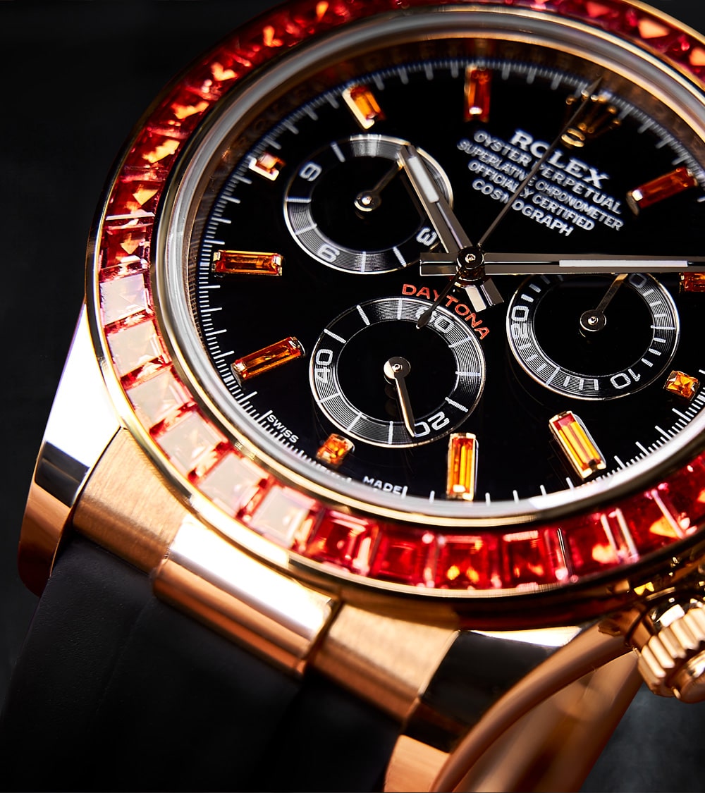 Image of a Rolex Daytona 40mm with a custom chronograph black dial and orange bezel by Cagau.