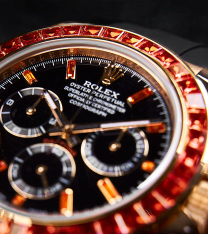 Image of a Rolex Daytona 40mm with a custom chronograph black dial and orange bezel by Cagau.