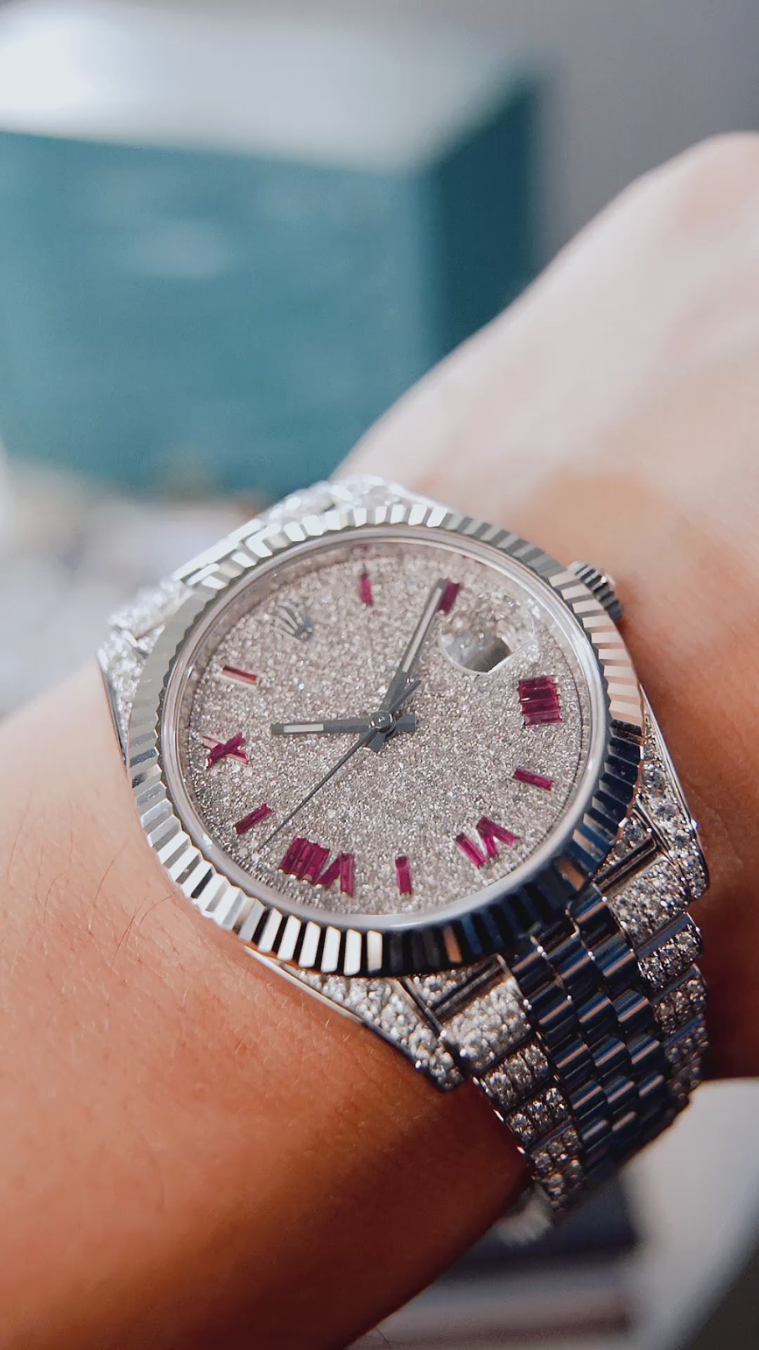 Video of a Rolex Datejust 41 with a custom diamond-set case and bracelet featuring a dial with ruby-colored Roman numeral markers by Cagau.